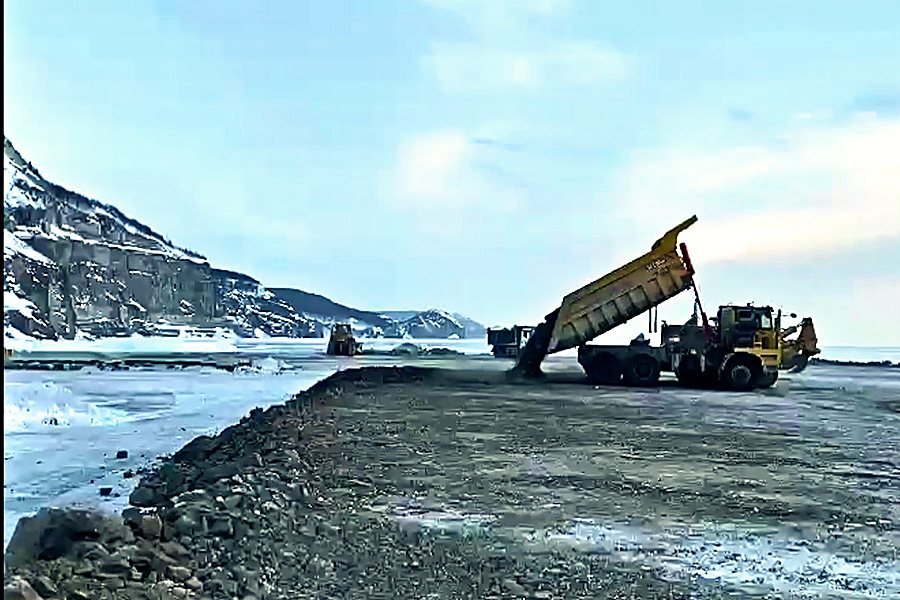 Отсыпка земляного полотна: самосвал разгружается в тело насыпи
