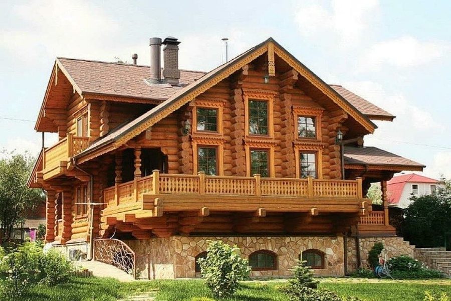 Русский стиль: дом из бревна с террасой и каменным цоколем
